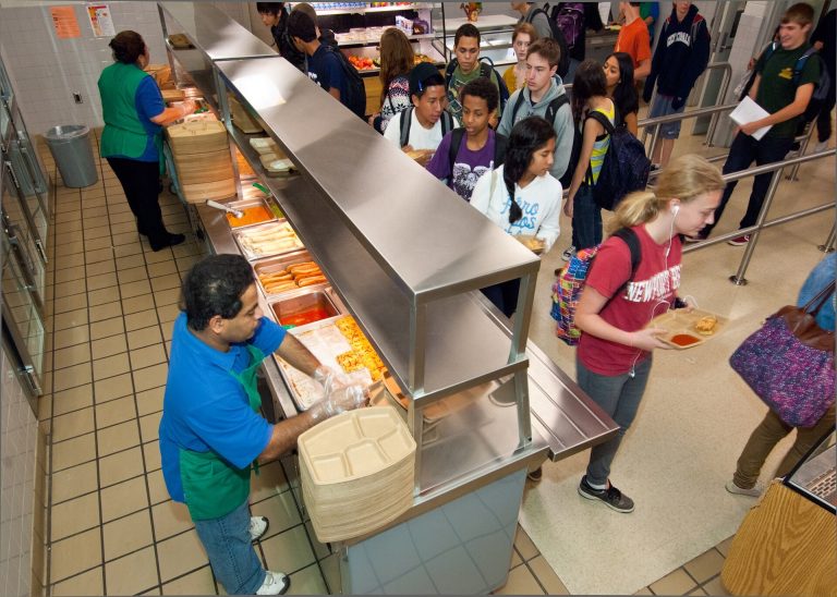 Teenagers sharing fresh fruit at a school lunch table
