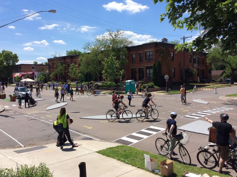Protected Bike Lanes Extend Toward the Suburbs cyclists using a protected bike lane